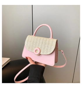 Detail of pink leather and woven straw crossbody bag with golden donut clasp closure