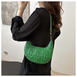 Detail of green crescent shoulder bag featuring unique 3D geometric texture and slim strap
