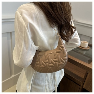 Detail of khaki crescent underarm bag showing T-shaped embossed quilting and gold hooks