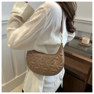 Detailed view of mocha leather crescent bag featuring 3D geometric textured embossing