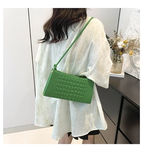 Close-up of bright green crocodile pattern texture on a stylish underarm bag for women