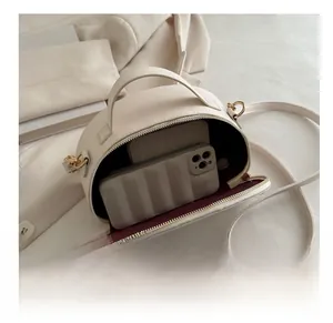 Internal view of cream minimalist crossbody bag showing capacity for phone and wallet