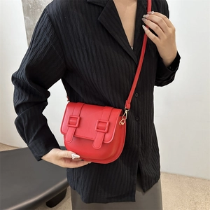 Chic red faux leather saddle bag worn by a model, featuring a modern half-moon design