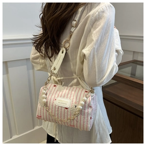 Détail du sac bandoulière à fleurs cerise avec élégante chaîne en perles et logo