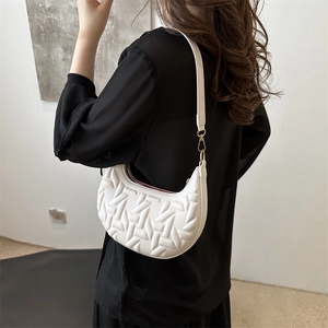 Minimalist white half-moon underarm bag with geometric embossed texture and gold metal clasp