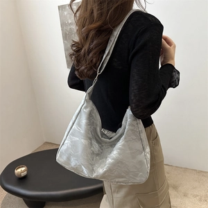 Grande borsa hobo grigio argento con texture increspata indossata da modella