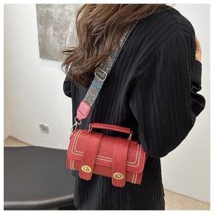 Détail du sac Boston cylindrique rouge foncé en cuir PU avec bandoulière tissée
