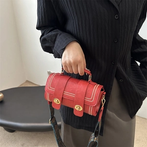 Sac Boston cylindrique rouge rétro avec rivets dorés et large bandoulière de style ethnique