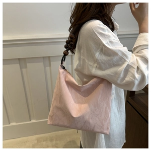 Detail of light pink shoulder bag with natural texture and decorative wood beads
