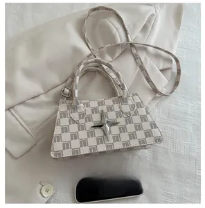 Mini trapezoid crossbody bag in grey checkered pattern with silver star buckle and phone comparison