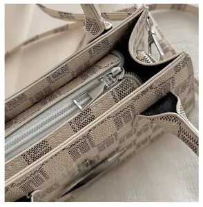 Detail of smooth silver zipper and plaid synthetic leather on the women's handbag