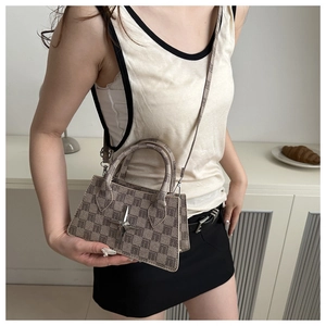 Detail view of beige checkerboard crossbody bag with silver star logo and top handles