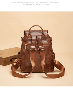 Dettaglio dello zaino vintage in pelle marrone con spalline regolabili e tasca posteriore