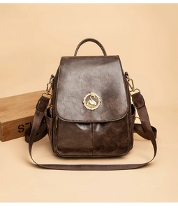 Dettaglio dello zaino marrone scuro con fibbia a cigno dorata e trama in pelle vintage