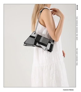 Detail of color-block geometric small square bag with metallic silver chain strap