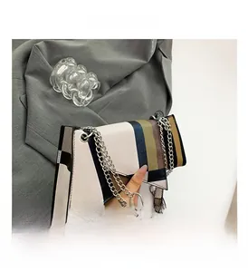 Detail of geometric color-block handbag with silver chain strap and modern finish
