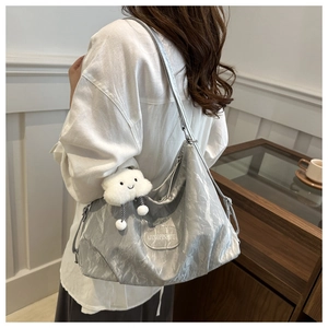 Détail du sac hobo argenté avec texture froissée et breloque nuage mignonne