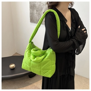 Close-up of vibrant neon green quilted tote bag showing puffy texture and stylish padding