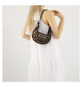 Detail of leopard print hobo bag with gold buckle and fuzzy texture on a model