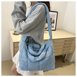 Détail du sac bandoulière matelassé bleu clair avec texture rembourrée et sangle