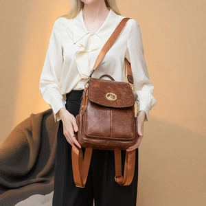 Zaino retrò da donna in pelle PU marrone scuro con emblema dorato e tracolla regolabile