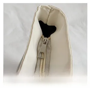 Detail shot of smooth silver metal zipper on white tote bag with neat stitching