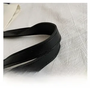 Detailed close-up of reinforced black faux leather handles with durable double stitching