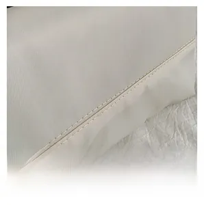 Detailed close-up of parallel stitching on durable twill nylon fabric for shoulder bag