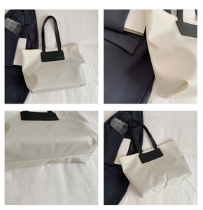 Detail view of the nylon tote bag showing the fashion logo and reinforced handle stitching