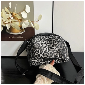Close-up of leopard print canvas bag with wide nylon strap and black label detail