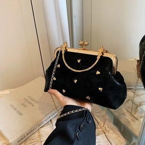 Elegant black velvet handbag with golden heart studs and vintage metal kiss-lock closure
