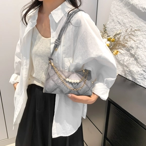 Sac hobo gris matelassé avec chaîne de perles élégante porté par un mannequin chic