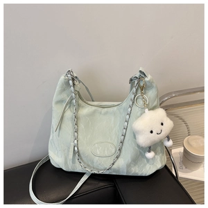 Detalle del bolso hobo verde menta con cadena de metal y colgante de nube suave