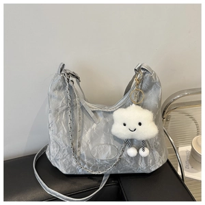 Detalle de bolso hobo plateado con textura arrugada y colgante de nube de peluche