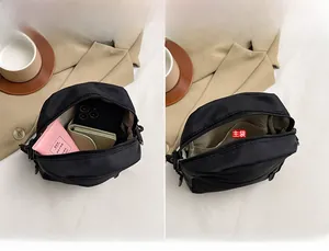 Detailed view of spacious interior pockets in a black canvas crossbody waist bag