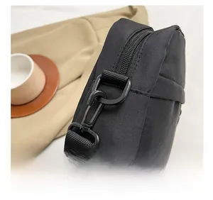 Detail of durable black nylon crossbody bag featuring sturdy rotating swivel snap hooks