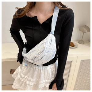 Close-up of the light blue wrinkled fabric texture and zipper on the casual chest bag