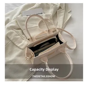 Detailed interior of the cream tote bag showing multi-layer capacity and phone pocket