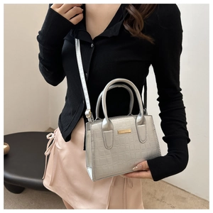 Close-up of silver crocodile embossed faux leather handbag with metallic detail