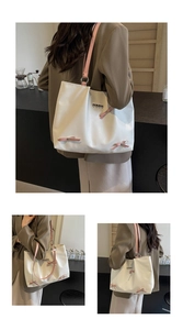 Detail of pink bow ribbons and metal heart pendants on a white nylon tote bag