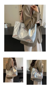 Detail of silver tote bag with pink bow accents and heart-shaped metal charm decoration