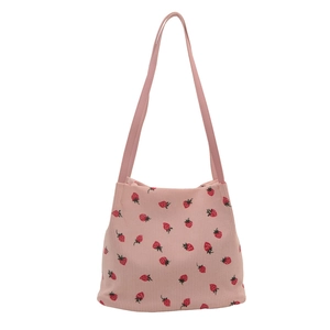 Pink corduroy tote bag with strawberry print and shoulder straps on white background