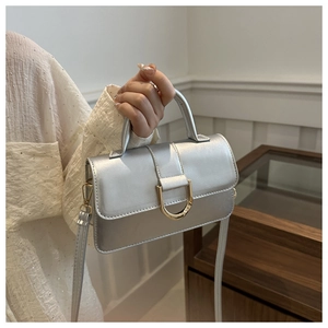 Detailed view of silver metallic PU leather handbag with gold D-ring buckle and handle