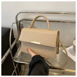 Détail du sac à main beige minimaliste avec fermoir doré et poignée chic en cuir