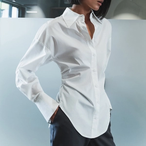 Chemise blanche cintrée en coton pour femme avec taille ajustée et ourlet arrondi élégant