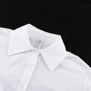 Détail du col classique et du bouton sur une chemise blanche en coton à manches longues