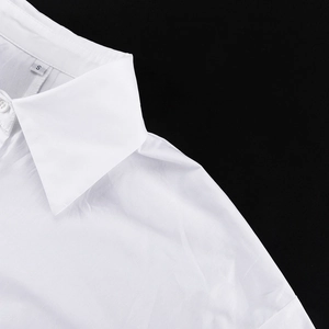 Gros plan détaillé d'un col de chemise en coton blanc avec coutures et étiquette
