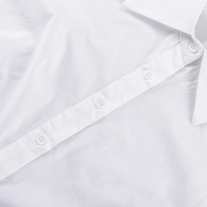 Détail d'une chemise en coton blanc montrant le col et les boutons à quatre trous