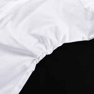 Gros plan détaillé des plis latéraux et des coutures de la chemise blanche en coton