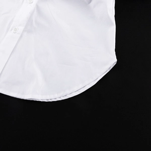 Détail de l'ourlet arrondi d'une chemise en coton blanc avec coutures de qualité